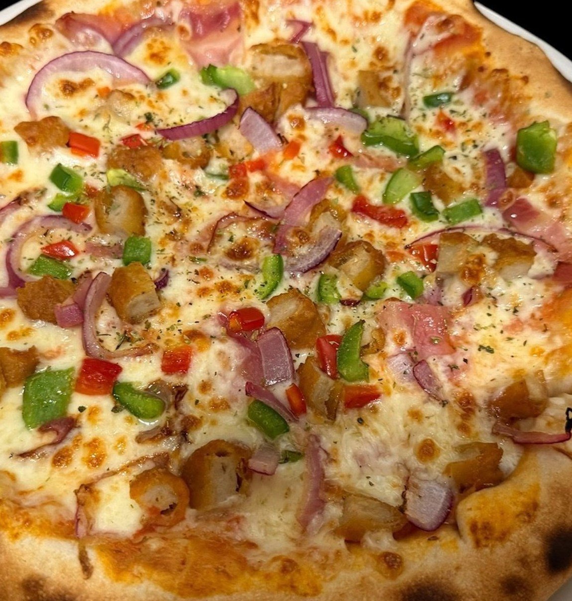 Pizza de pollo, pimiento, cebolla morada y bacon de Mr. Singh's